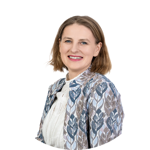 Alexandra sitzt aufrecht und lächelt gerade in die Kamera